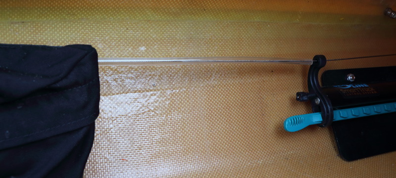 a sea kayak's rudder cable, covered in protective plastic tubing