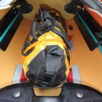 a drybag strapped to anchor points in a kayak's cockpit