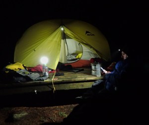 A tent and camper at night