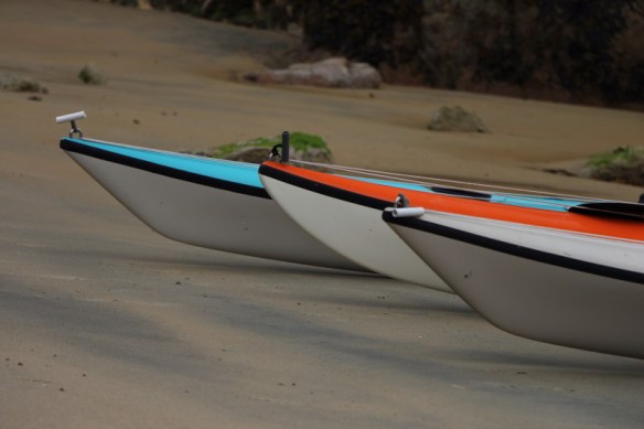 the bows of three sea kayaks in a row