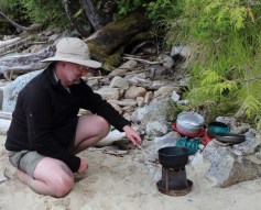 a camper cooks on a portable woodstove