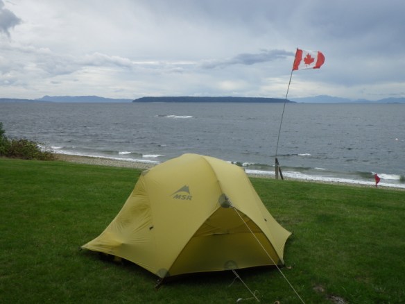 a tent next to a flag pole in strong wind