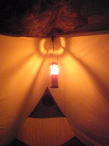 a candle lantern hanging inside a tent