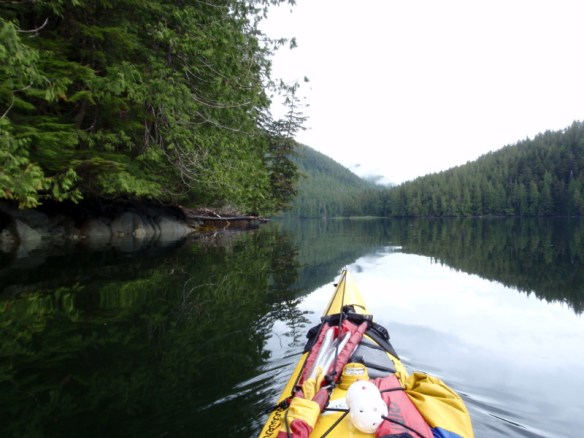 a calm inlet viewed over the bow of a kayak 
