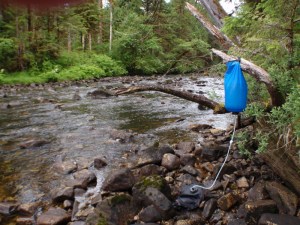 a gravity fed water filteration bag next to a creek