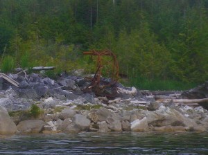 rusty mining equipment on a rocky shore