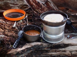 a campstove with baked beans and bannock
