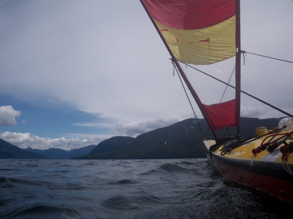a sea kayak under sail, viewed from water level
