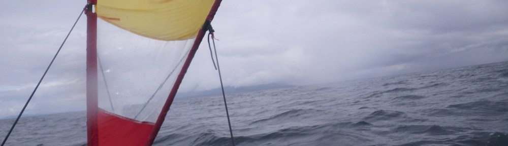 a kayak under sail in a high wind