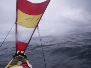 a kayak under sail in a high wind