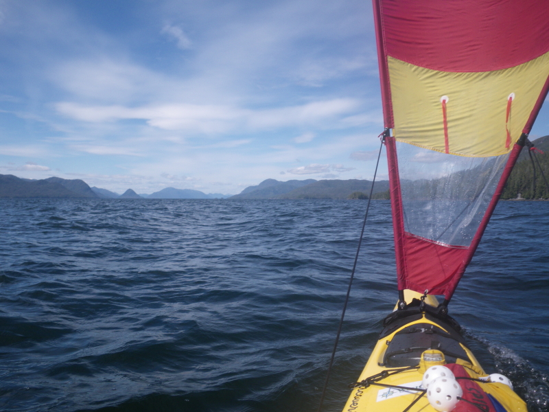 A sea kayak sailing north. Swindle Island and Cone Island, British Columbia are visible on the horizon.