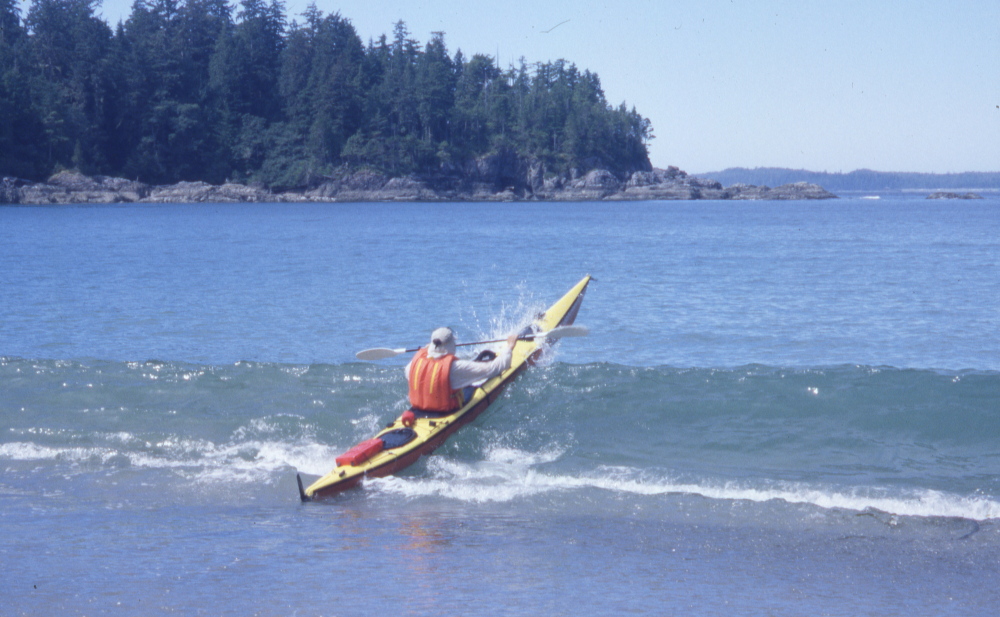 a sea kayak breaks out through surf