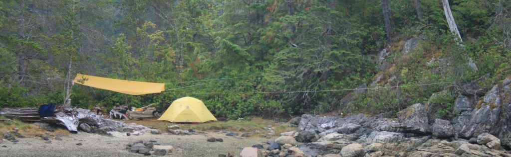 Showing a tarp rigged with very long lines, anchored to rock and trees up to a hundred feet away.