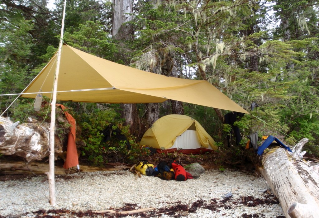 Showing a camp tarp rigged in an A-frame configuration