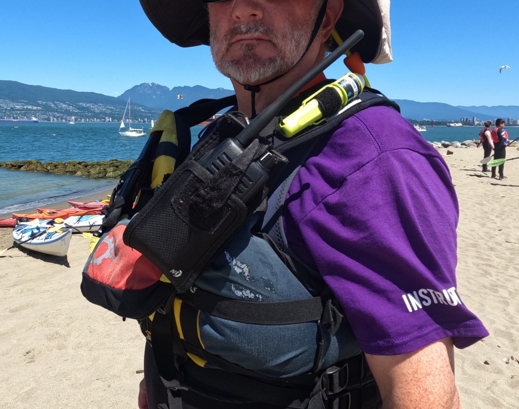 a photo of a holster for a marine VHF radio, mounted on a sea kayaking PFD